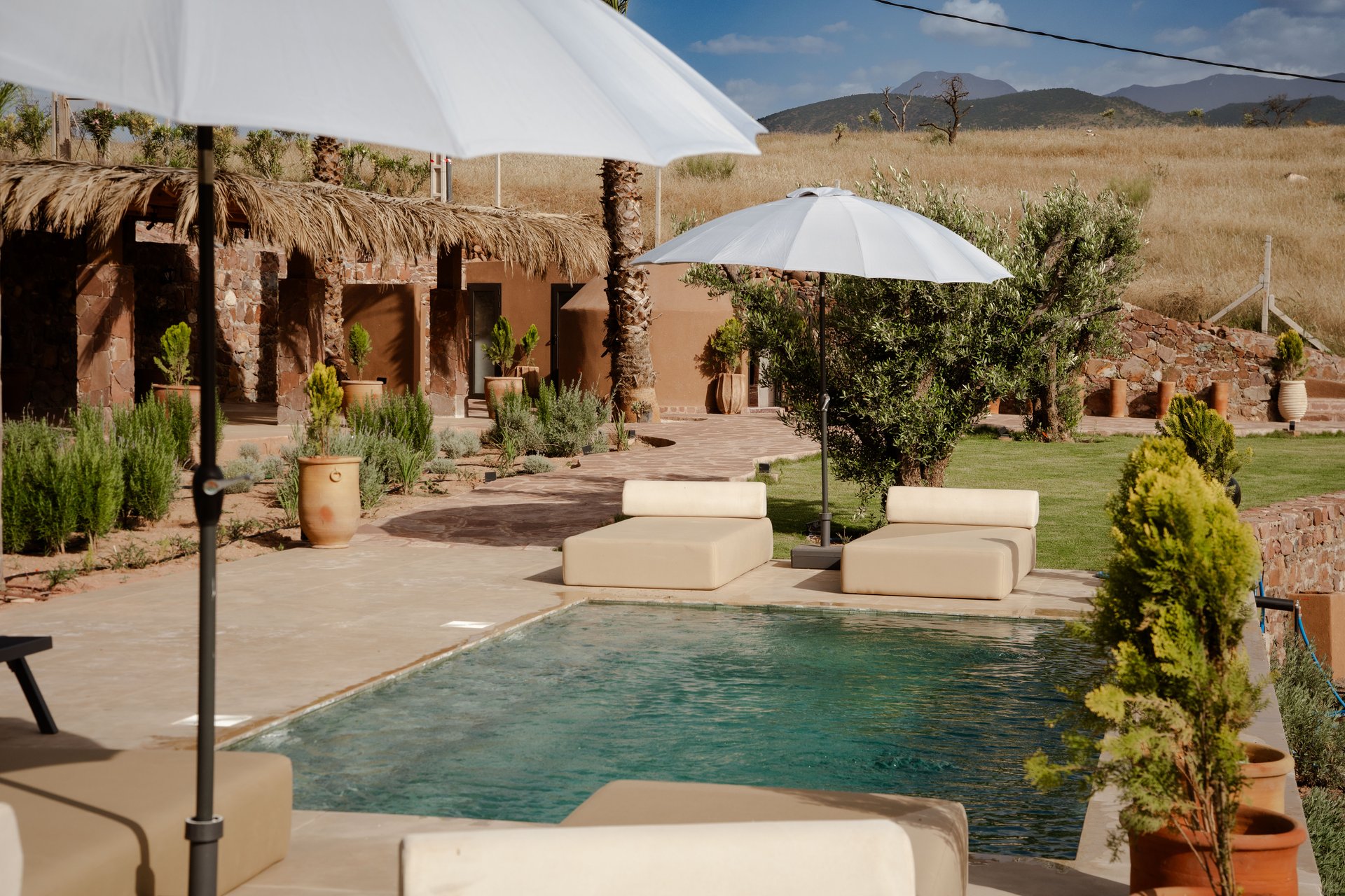 Piscine turquoise, jardin paysagé et terrasse ombragée